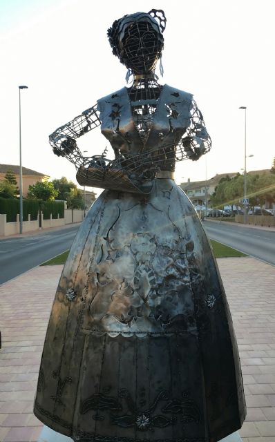 La escultura de una huertana en hierro repujado recuerda el 50 Aniversario del grupo Coros y Danzas Mar Menor, de San Javier